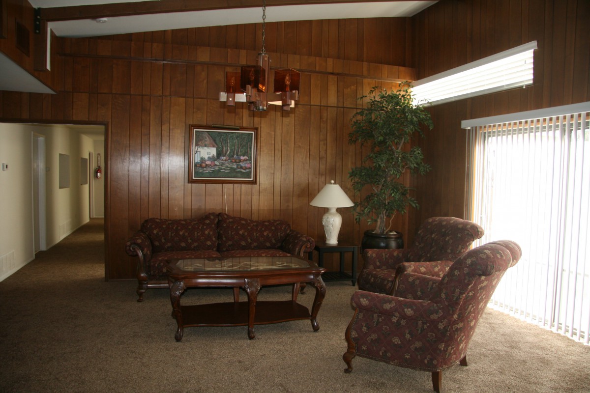 Cozy living room with wood paneling and classic furniture.