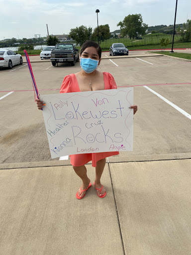A participant holding a sign while wearing a mask, advocating for a cause in an outdoor setting.