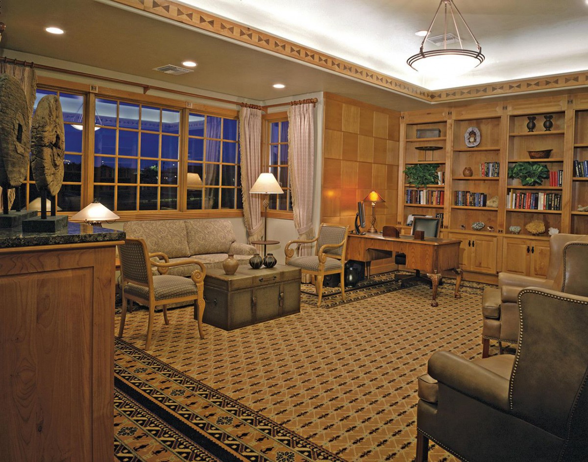 A cozy living room with comfortable seating, bookshelves, and warm lighting.