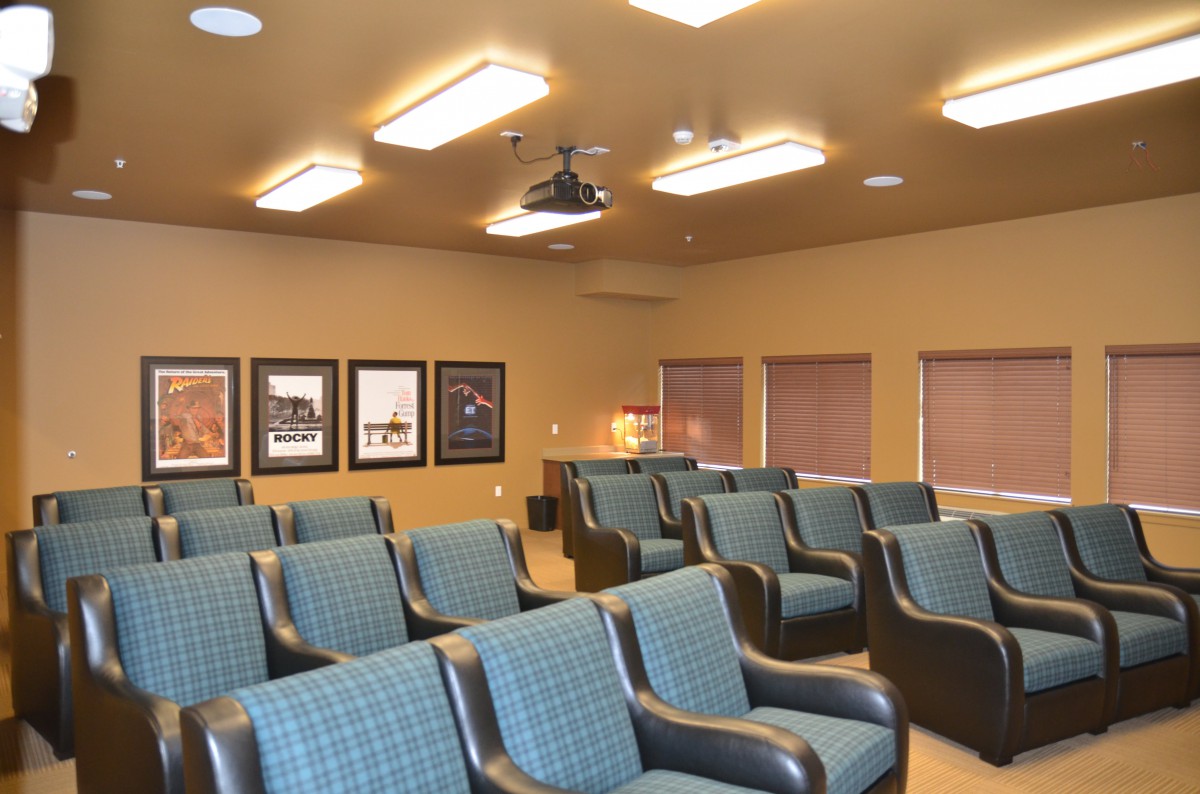 A small theater room with comfortable seating and a projector.