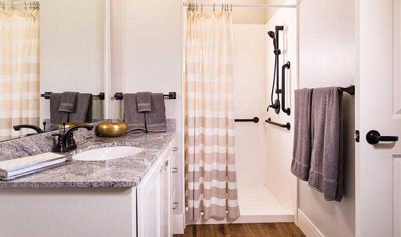 A modern bathroom with a shower, striped curtain, and neatly arranged towels.