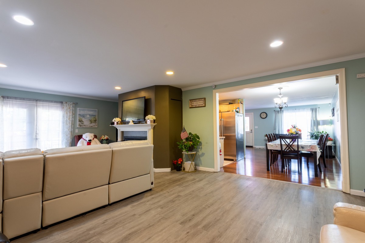 A modern living room with an open layout featuring a comfortable couch, fireplace, and wooden flooring.