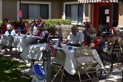 Residents enjoying a festive outdoor gathering, complete with decorations and American flags.