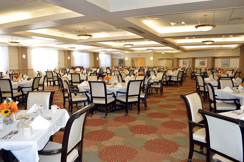 An empty dining room with neatly arranged tables and chairs ready for guests.