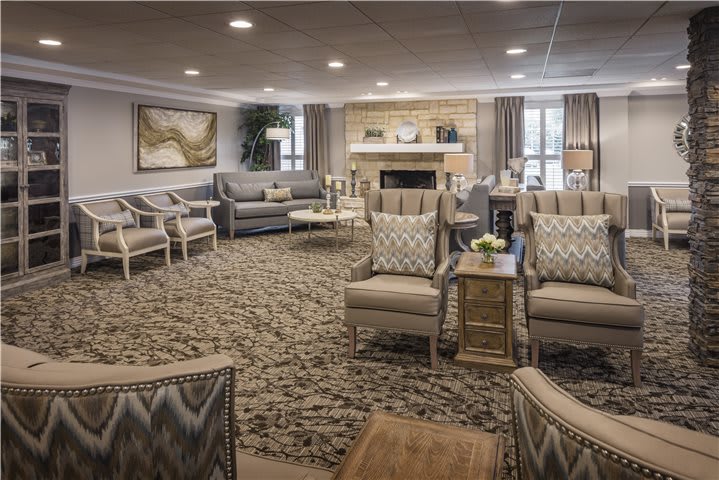 A spacious and elegantly designed living room with comfortable seating and a warm fireplace.