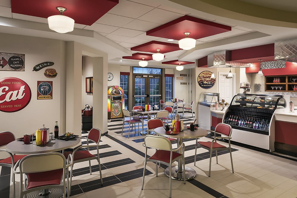 A retro diner with vintage decor featuring a checkerboard floor and red and white seating, reminiscent of the 1950s style.