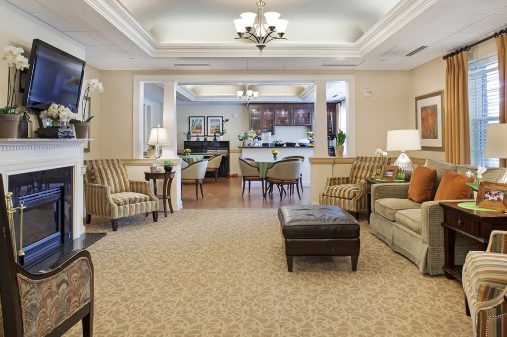 A spacious and elegantly designed living room with comfortable seating and a chandelier.