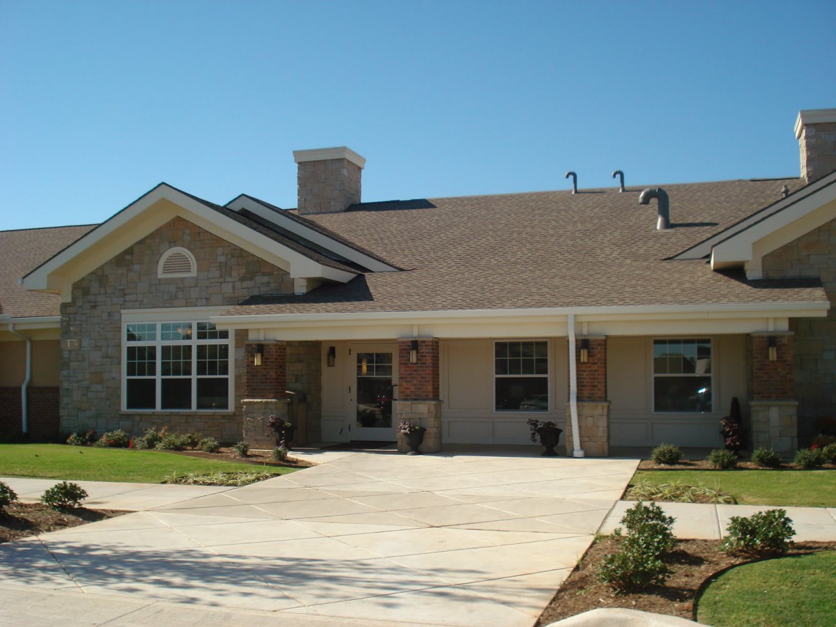 A suburban residential house with a driveway and landscaped front yard.