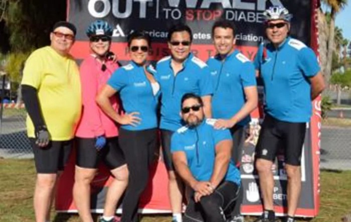 A group of people posing together at a diabetes awareness event, wearing matching blue shirts.