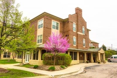A brick building with a flowering tree in front, capturing the essence of spring.