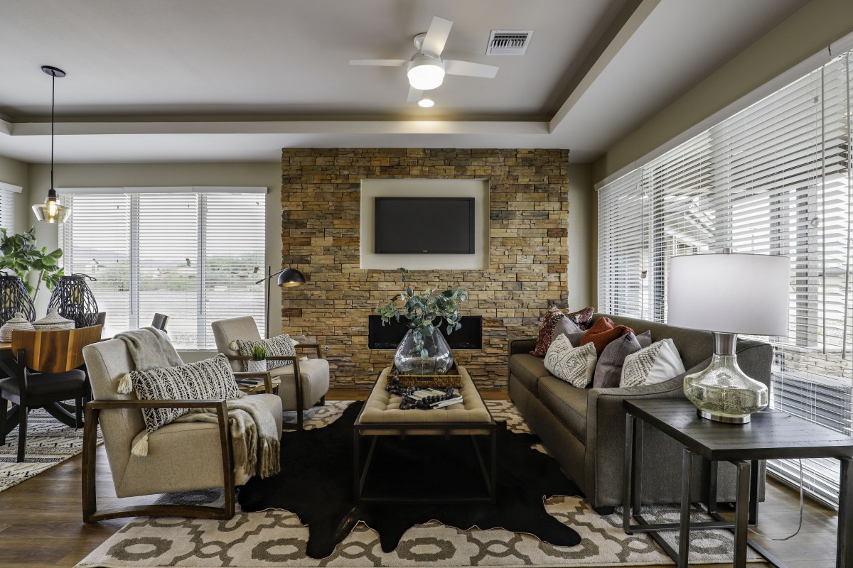 A cozy and modern living room with a stone fireplace and comfortable seating.
