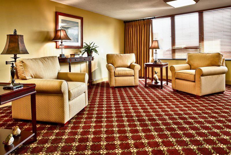 A cozy living room with armchairs and a patterned carpet.