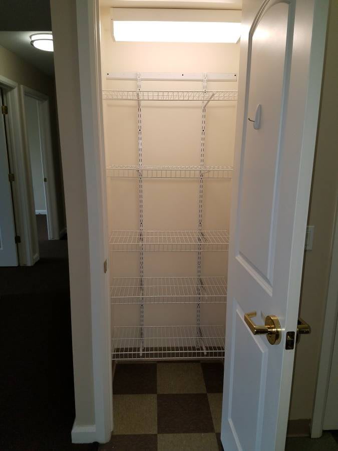 An empty closet with wire shelving and an open door.
