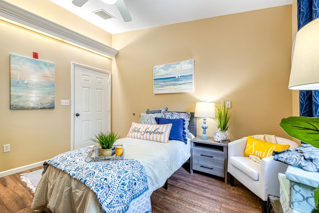 A cozy and modern bedroom featuring a single bed, an armchair, and vibrant decor.