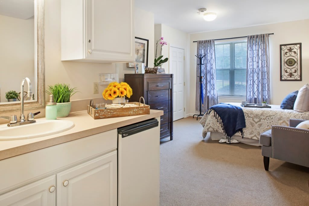 A cozy studio apartment with a kitchenette and a well-decorated bedroom area.