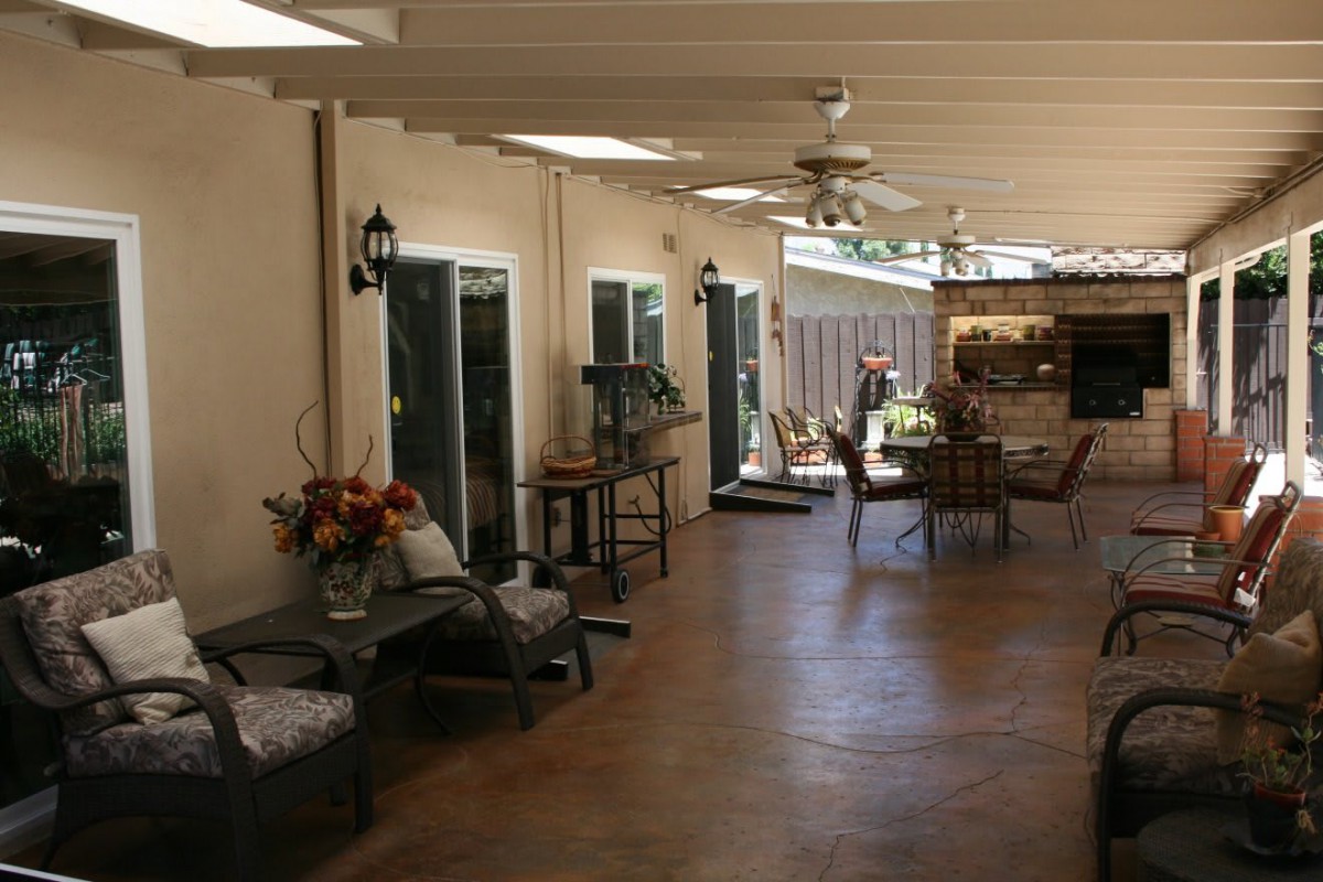 A spacious covered patio with comfortable seating and decor.