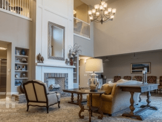 A spacious living room with elegant furnishings and a chandelier.