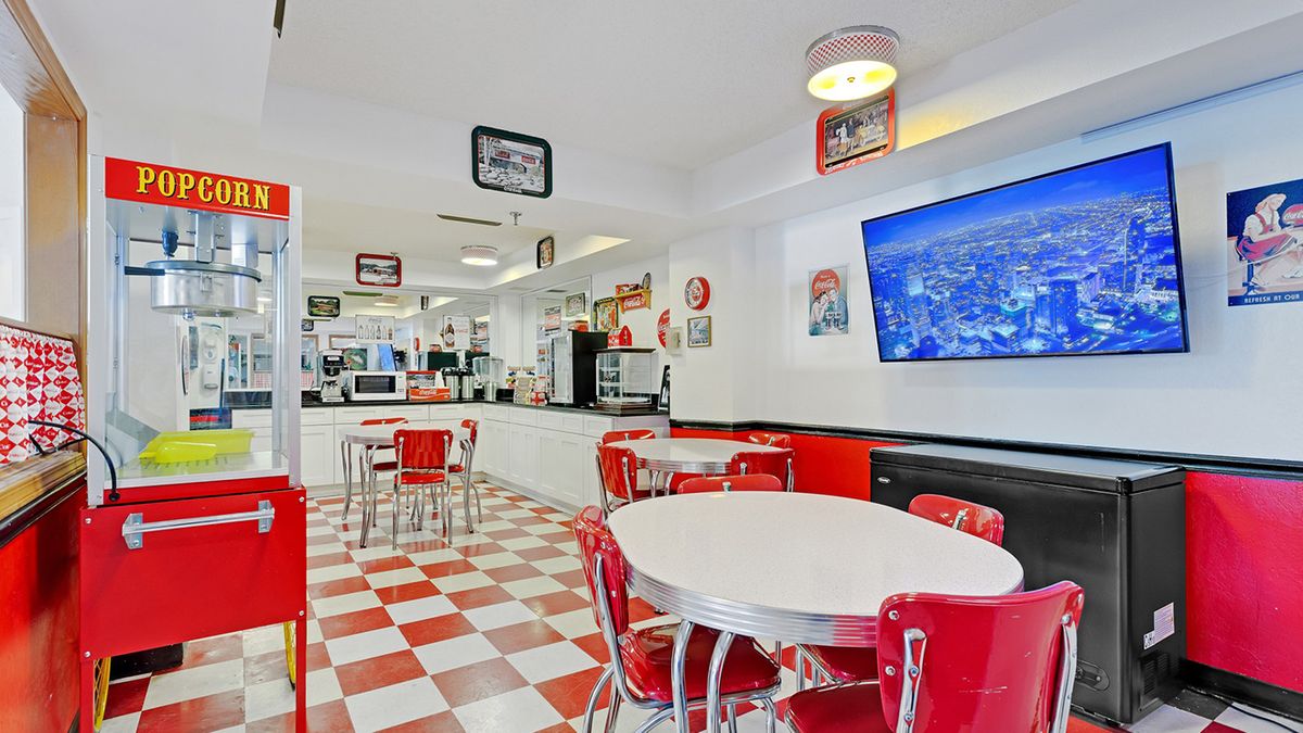 A retro-style diner with a red and white color scheme, featuring classic decor and checkered flooring.