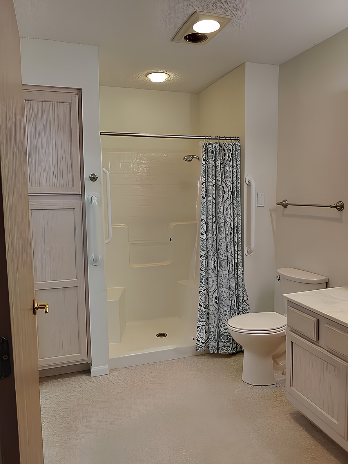 A modern bathroom with a glass shower, toilet, and sink.
