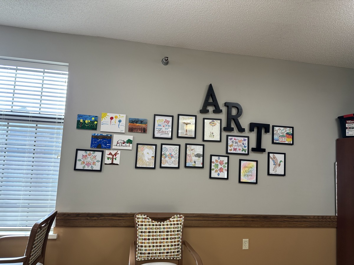 A wall display of various framed artworks arranged under large letters spelling 'ART'.