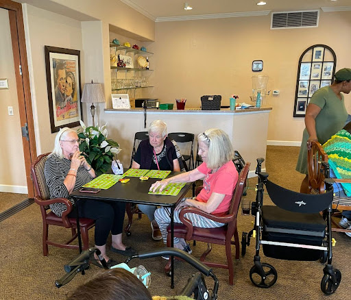 A group of seniors enjoying a social gathering in a comfortable indoor setting.