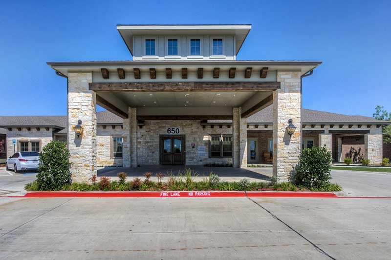 A modern building entrance with a stone facade and canopy.