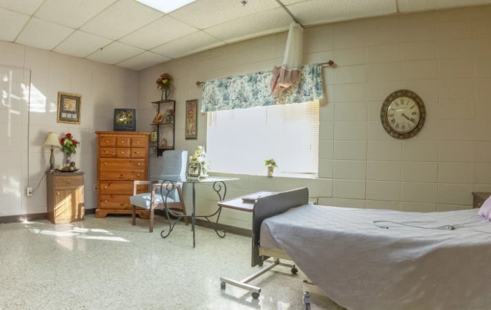 A clean and organized examination room in a healthcare facility, featuring medical equipment and furniture.
