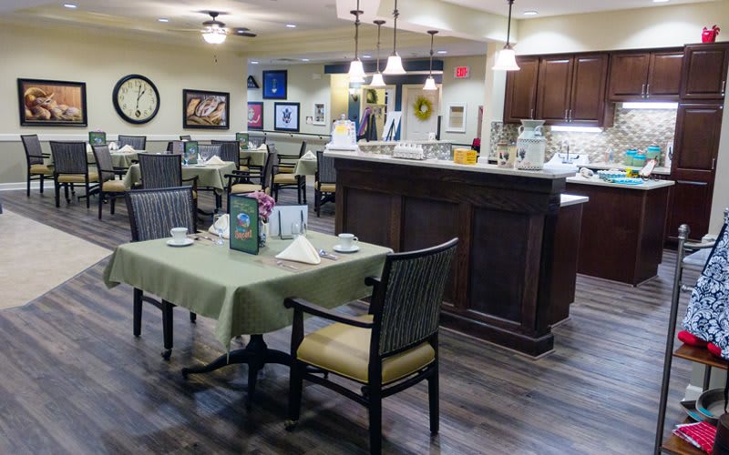 A cozy restaurant dining area with neatly set tables and warm lighting.