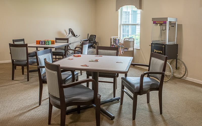 A well-lit room with a table and chairs, featuring various furniture items.