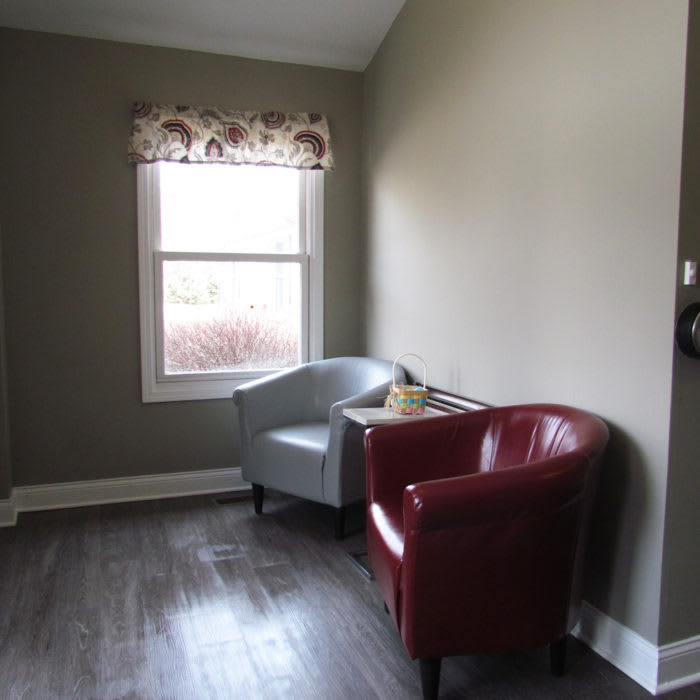 A minimalist room with two chairs and a window.