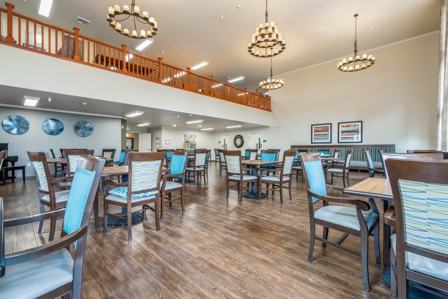 A spacious dining area with elegant chandeliers and modern furnishings.