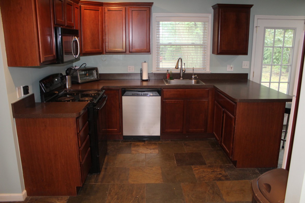 A modern kitchen with wooden cabinets and stainless steel appliances.