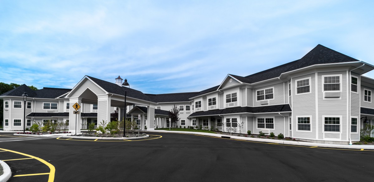 Exterior view of a large two-story residential building with a driveway.