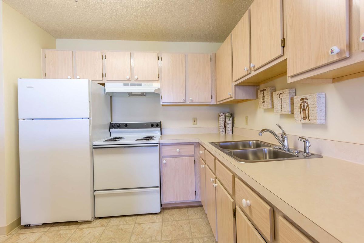 A residential kitchen with light-colored cabinets and standard appliances.