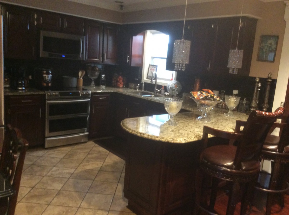 Modern kitchen with dark wood cabinets and granite countertops.