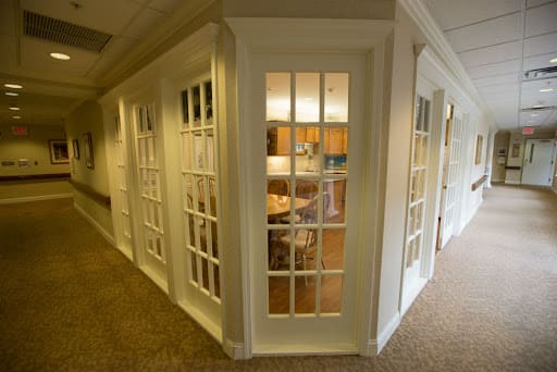A modern office space with glass-paneled doors and a view of the interior furnishings.