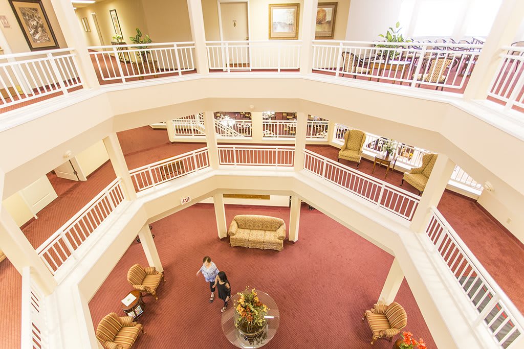 A spacious hotel lobby with multiple levels, featuring comfortable seating areas and elegant decor.