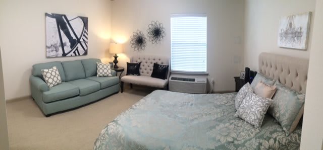 A cozy bedroom with a bed, sofa, and decorative elements.
