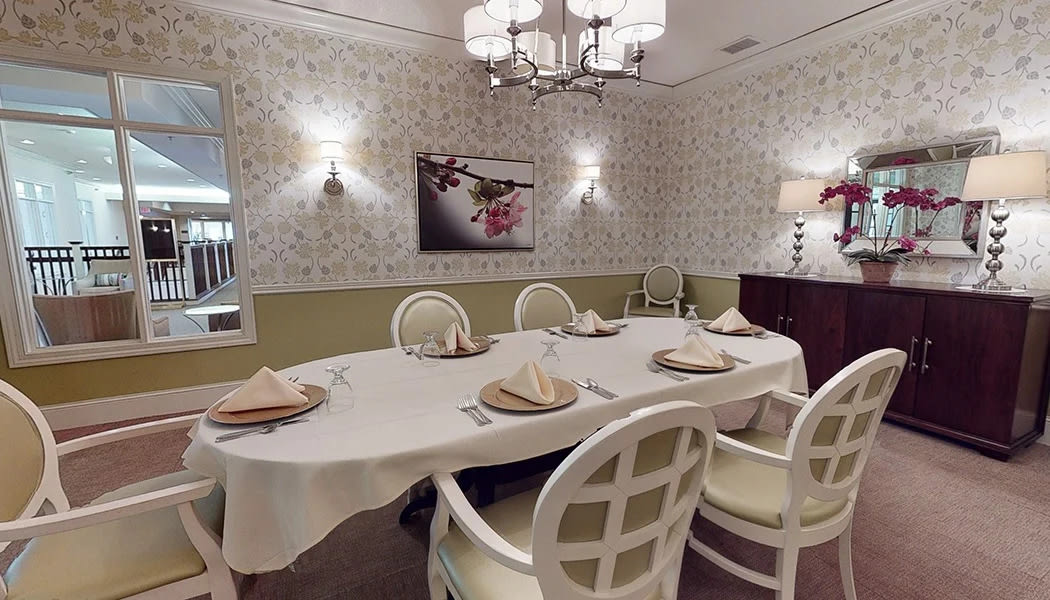 A beautifully decorated dining room featuring a table with place settings, elegant chairs, and ambient lighting.