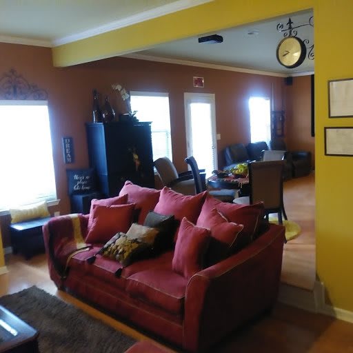 A cozy living room with a red sofa and ample natural light.
