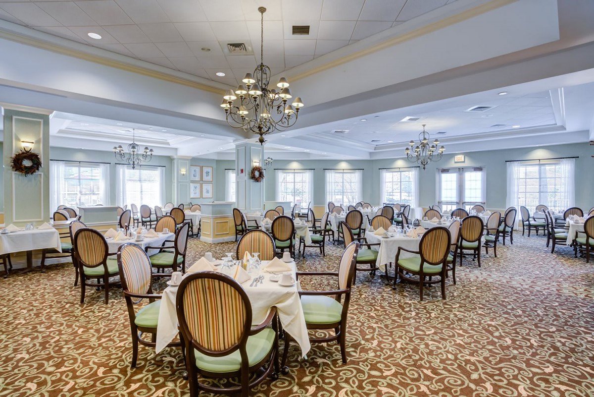 An elegant dining room with beautifully set tables and chandeliers.