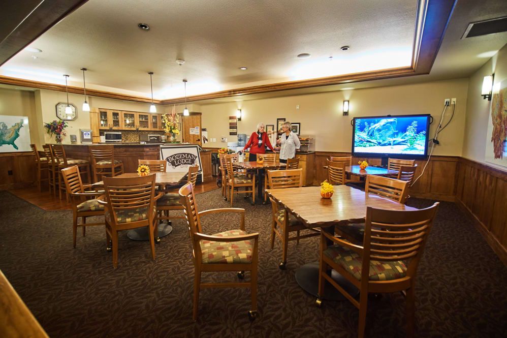 A cozy restaurant interior featuring a dining area with tables, chairs, and a television.