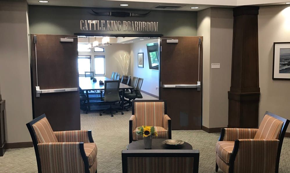 An open conference room with a table and chairs, seen through a welcoming lobby area.