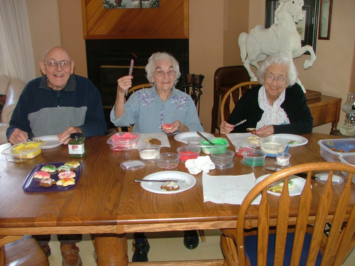 A group of elderly people engaged in a creative activity at a dining table.