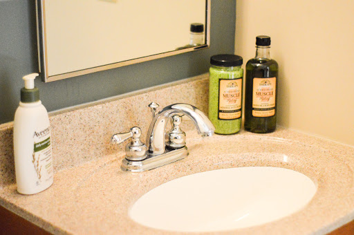 A stylish bathroom sink with a chrome faucet and neatly arranged personal care bottles.