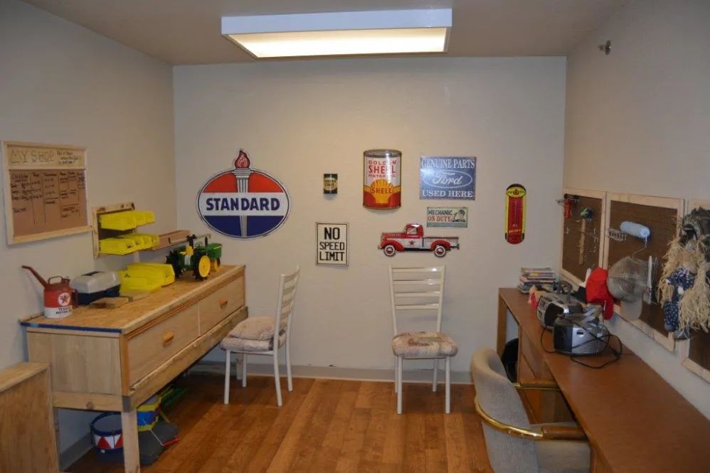 A cozy workshop featuring vintage signs and model car displays.