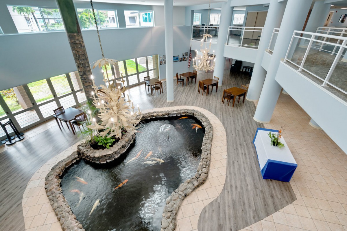 A modern atrium with an indoor pond and seating area.