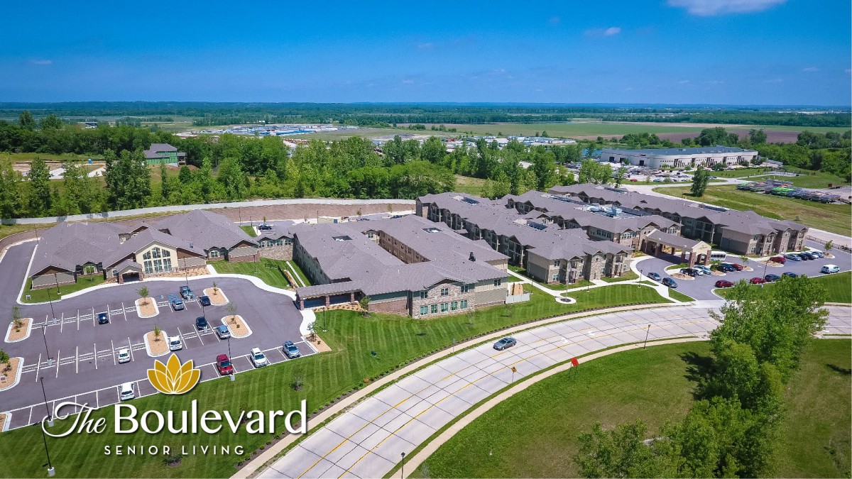 Aerial view of a residential complex with surrounding greenery and roads.