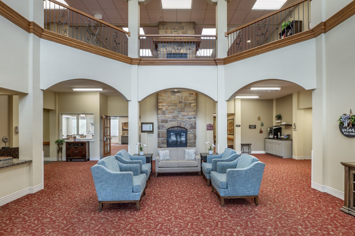 A spacious lobby with comfortable seating and a central fireplace.
