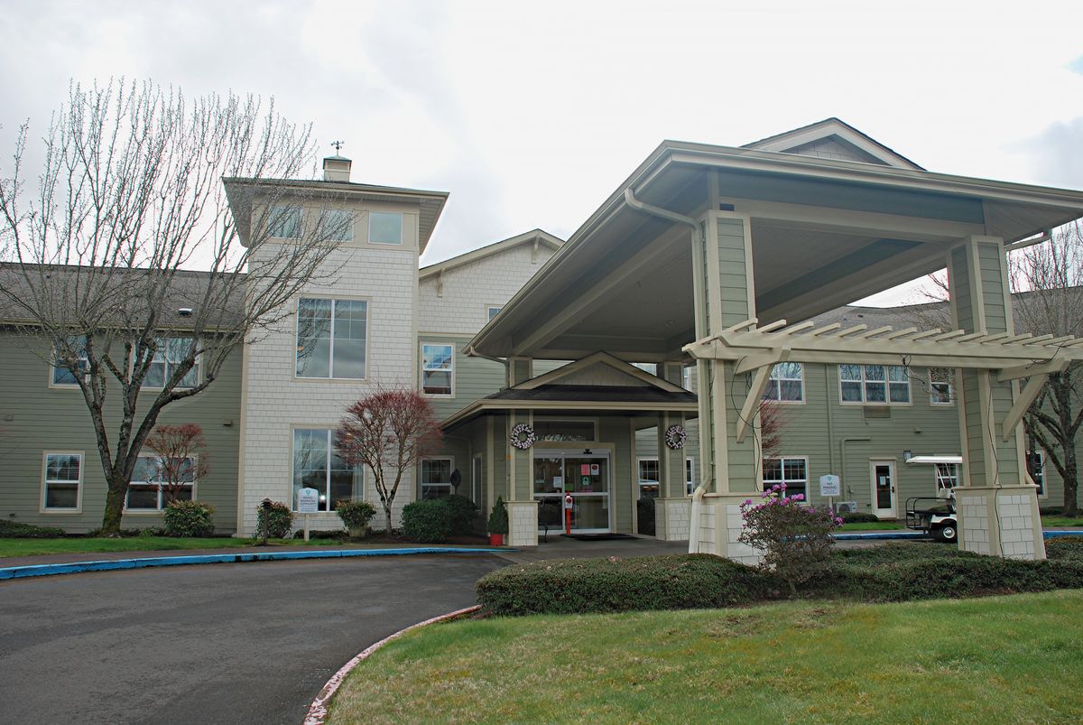 A building with a covered entrance and surrounding landscaped area.
